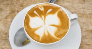 Cappuccino con disegno a forma di farfalla sulla schiuma di latte