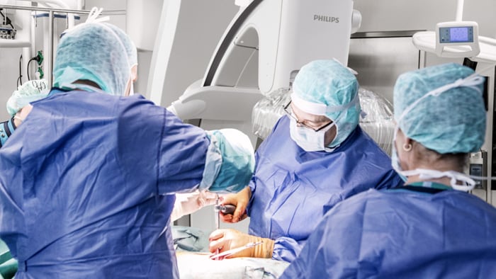 Chirurghi che guardano il monitor e discutono di come procedere con l'intervento di chirurgia vertebrale