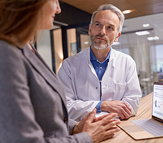 Un medico e un cliente che discutono dei dati su un notebook
