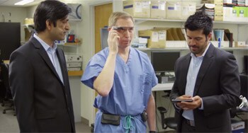 Un medico attiva i Google Glass mentre parla con due sviluppatori.