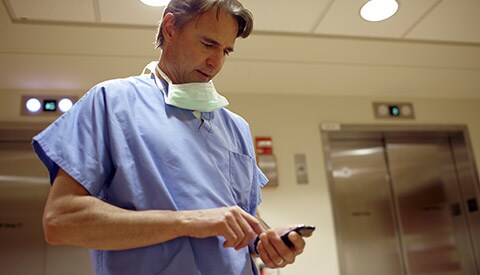 Un medico esamina le cartelle cliniche dei pazienti su un dispositivo mobile