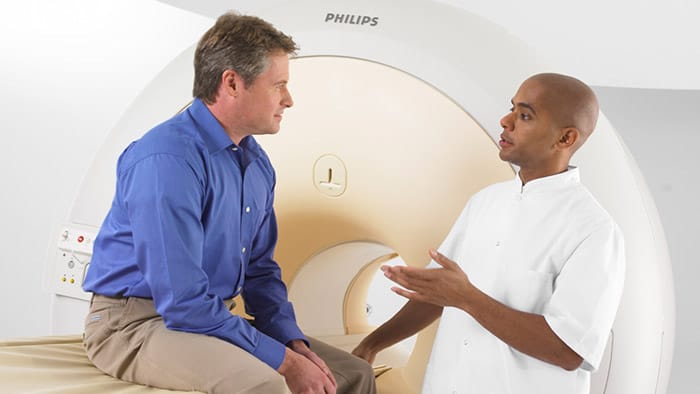 un uomo che parla con un uomo in una macchina per la scansione TC