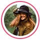 : Immagine del profilo dell’utente, una donna dai capelli rossi sorridente con un cappello nero.