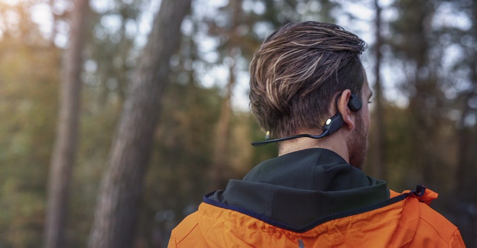 Uomo che indossa le cuffie wireless durante un allenamento all'aperto.