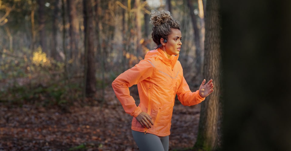 Atleta che utilizza cuffie a conduzione ossea wireless per la corsa all'aperto