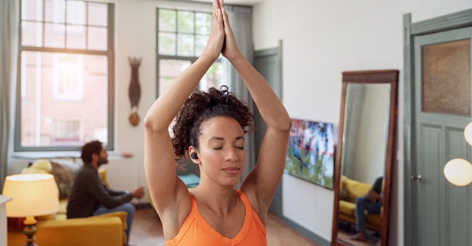 Atleta che utilizza comode cuffie true wireless durante lo yoga