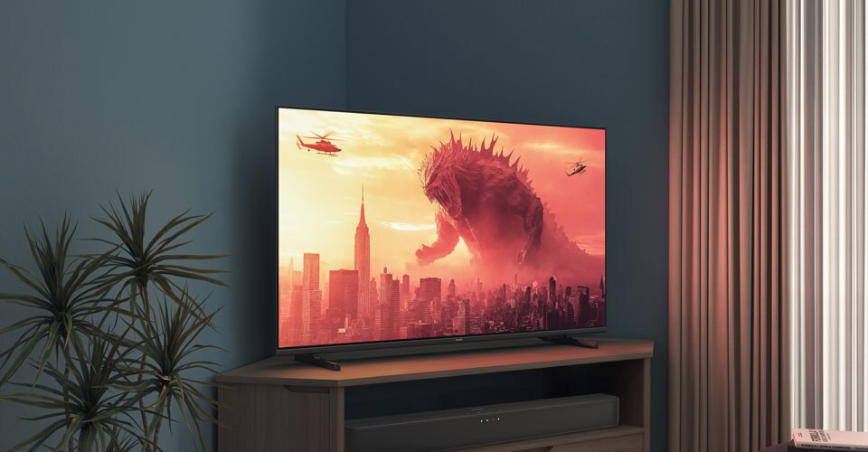 Una TV Philips su un supporto angolare mostra un film di Godzilla
