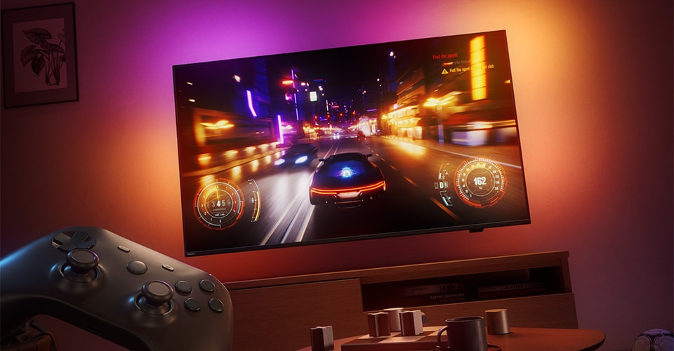 Un videogioco di corse viene visualizzato su un televisore Philips Ambilight in una stanza scarsamente illuminata