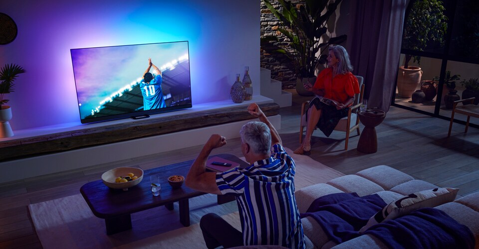 La famiglia sta guardando una partita con il televisore OLED