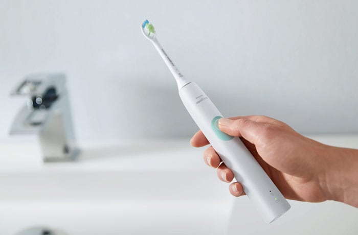 Foto in primo piano di uno spazzolino elettrico Philips Sonicare bianco.