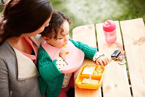 Mamma e bambino che fanno una merenda fuori casa