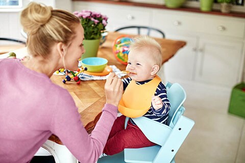 Mamma che dà la pappa al bambini