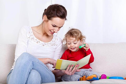 Mamma che legge un libro con il suo bimbo