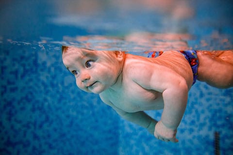 Bebè che nuota in piscina