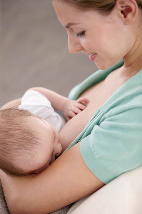 Mamma che allatta al seno il suo bambino in un luogo pubblico