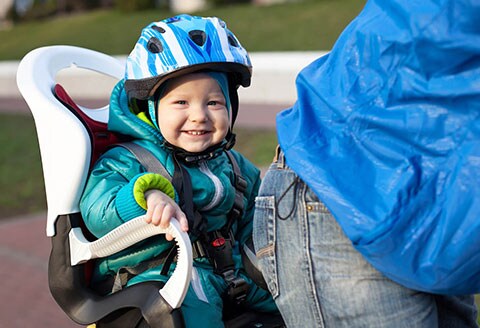 Bimbo seduto sul seggiolino posteriore in bicicletta