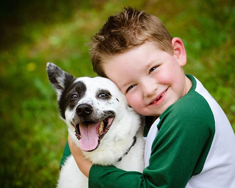 Bimbo che abbraccia il suo cane