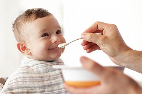 Bimbo durante lo svezzamento che mangia la pappa.