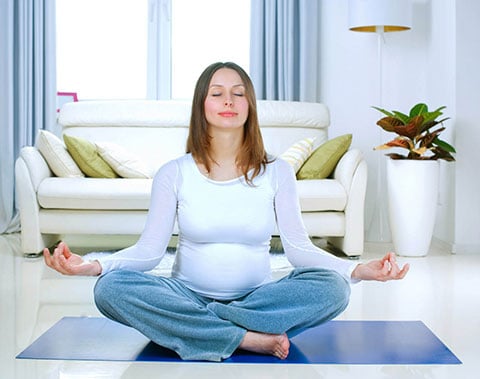 Mamma in gravidanza che fa yoga