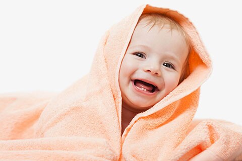 Bimbo che sorride con i suoi primi dentini da latte