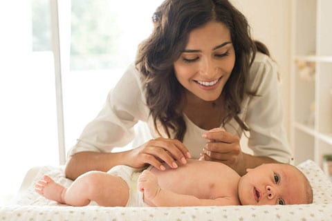 Giovane mamma si occupa delligiene e della cura del suo bebè