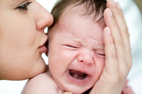 Mamma che consola neonato che piange