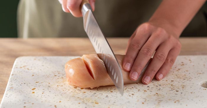 Usare un coltello affilato per incidere 4-5 fessure (regolarsi in base alle dimensioni del pezzo di carne) lungo i petti di pollo.