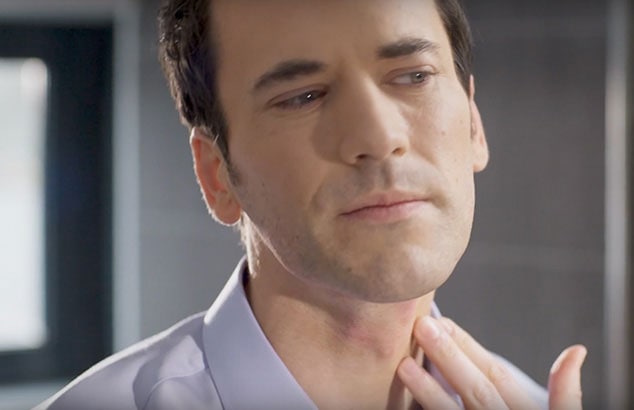 un uomo ben rasato che passa le dita su alcuni segni rossi sul collo.