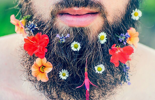 Primo piano della barba di un uomo con molti fiori diversi e colorati.